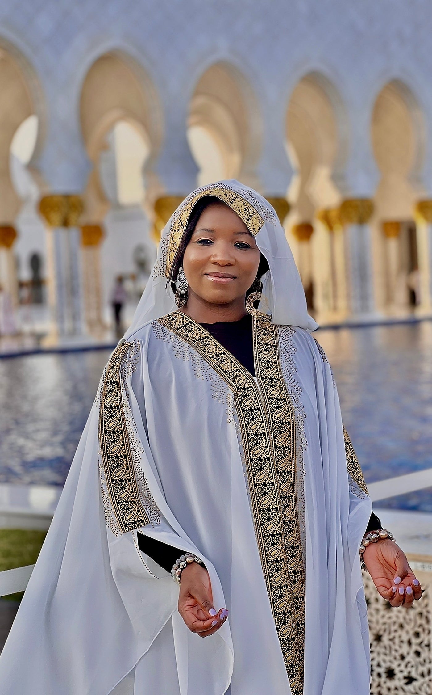 The courtyard of the Sheikh Zayed Grand Mosque in Abu Dhabi, with marble inlaid floral patterns reflecting evening light